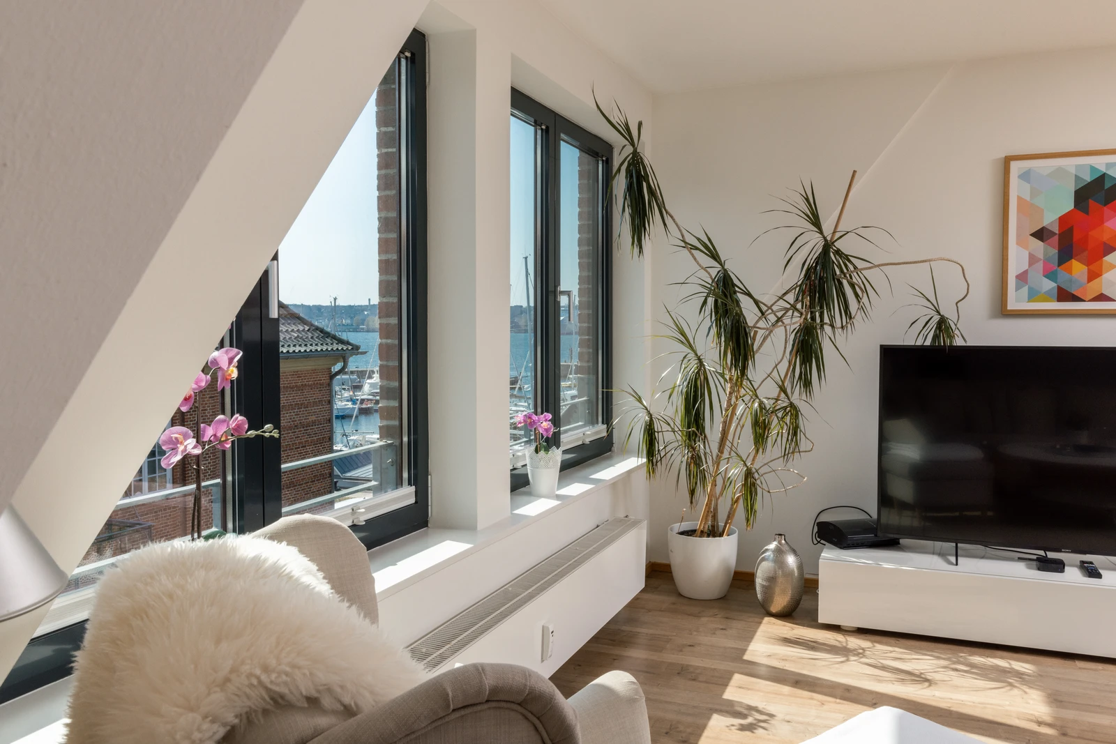 Fensterfront mit Zimmerpflanze im Wohnzimmer der Ferienwohnung Seestern