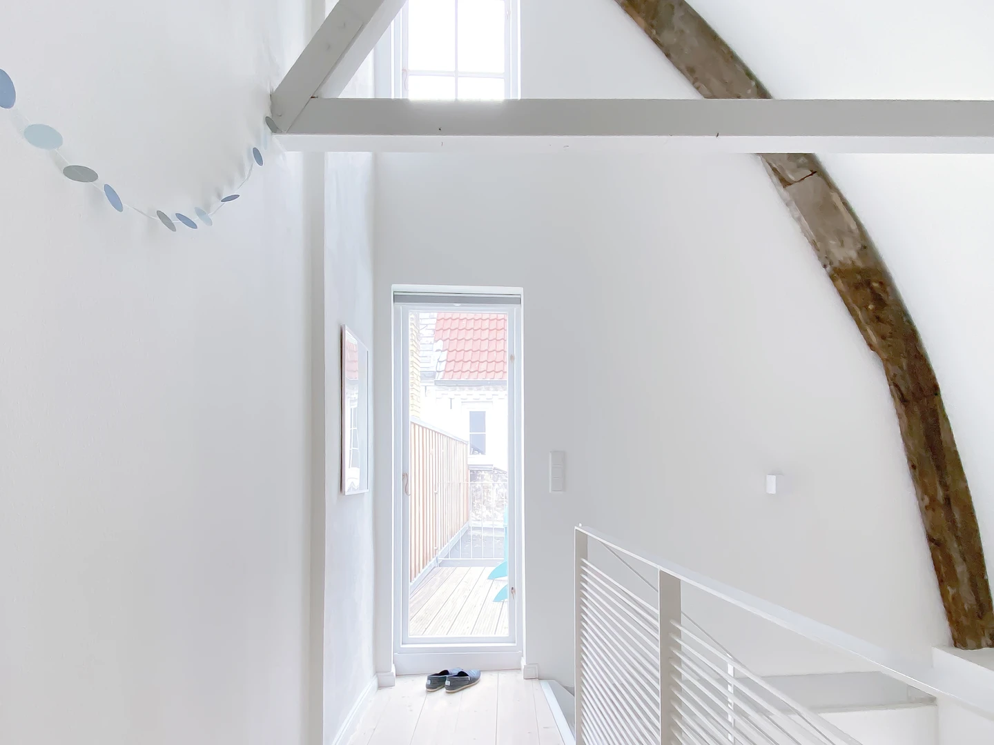 Offene, weiße Balken im Galeriebereich über der Treppe, vor Balkonzugang