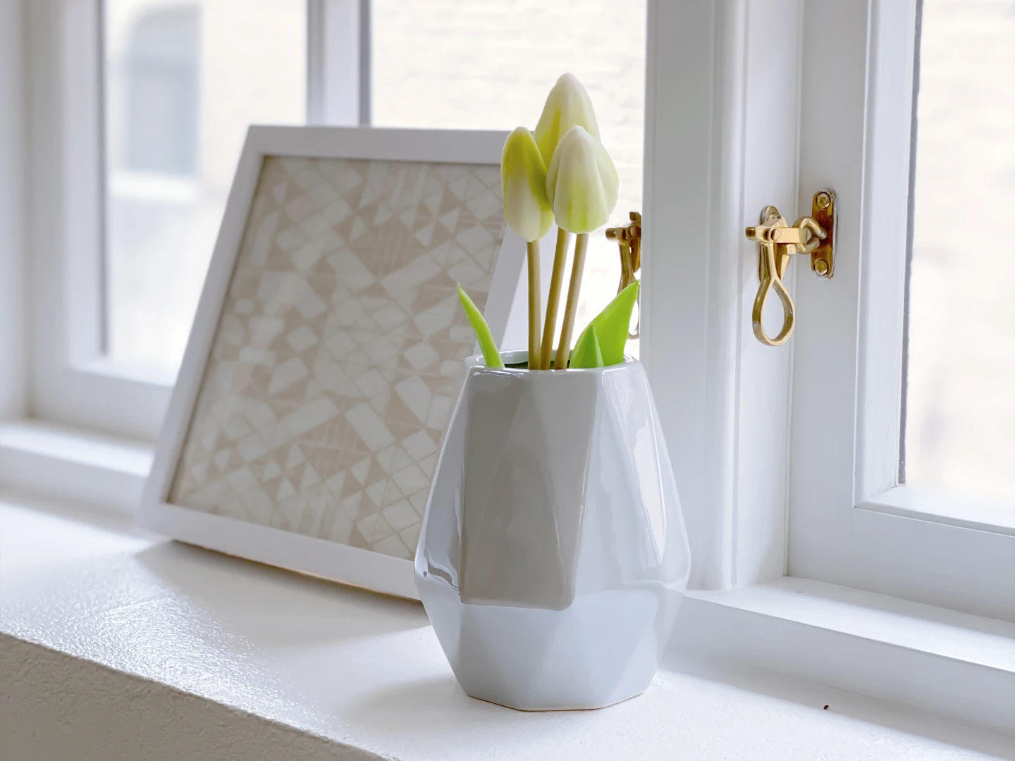Weiße Vase auf Fensterbank mit Holzfenstern