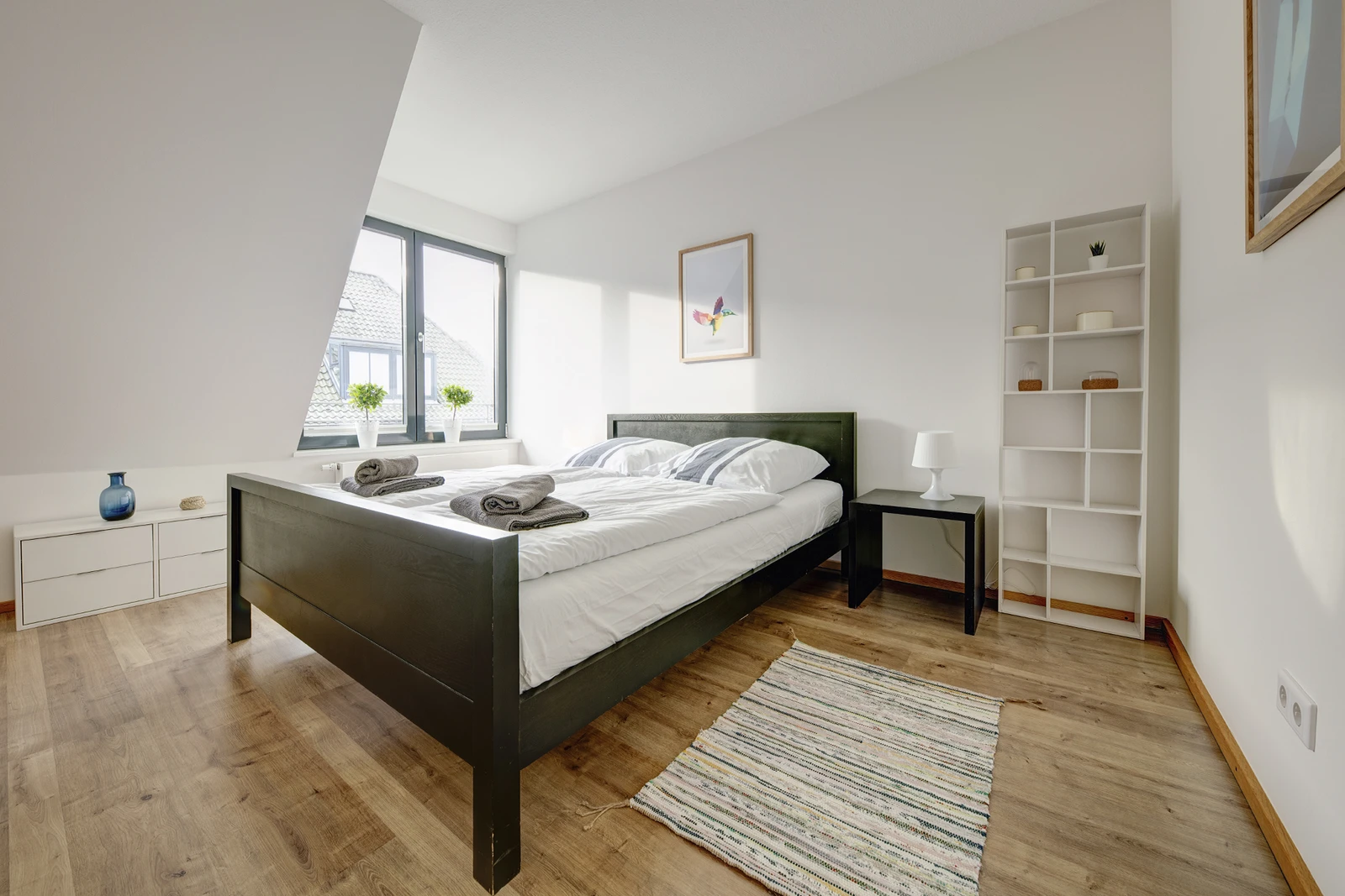 Dunkles Bett in hellem Schlafzimmer